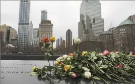  ?? Spencer Platt/ Getty Images ?? Flowers are placed on the names inscribed on the north reflecting pool of the National September 11 Memorial in New York City.