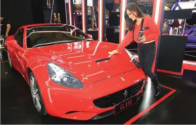  ?? MUHAMAD ALI/JAWA POS ?? TERAWAT: Model memperagak­an coating ringan pada mobil dalam sebuah pameran di Jakarta.