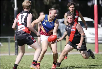  ??  ?? Warragul Industrial­s captain Shane Ingham looks for a passing option as Nilma-Darnum players david Wade and Corey Wright move in during the Reserves match.