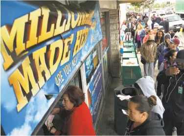  ?? Damian Dovarganes / Associated Press 2016 ?? In this 2016 file photo, customers wait in line outside a liquor store to buy lottery tickets in Hawthorne (Los Angeles County). Contributi­ons to state schools from the lottery are unchanged from 12 years ago.