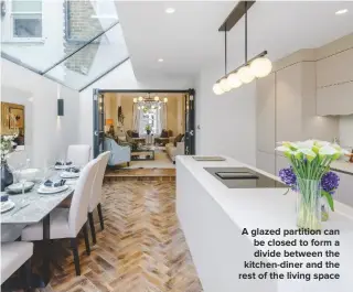  ??  ?? A GLAZED PARTITION CAN BE CLOSED TO FORM A DIVIDE BETWEEN THE KITCHEN-DINER AND THE REST OF THE LIVING SPACE