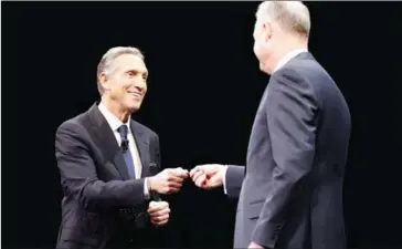  ?? JASON REDMOND/AFP ?? Starbucks chairman and CEO Howard Schultz (left) hands over the key to the original Starbucks store to president and COO Kevin Johnson in Seattle, Washington, on Wednesday.