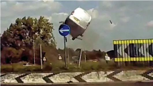  ??  ?? Rocket van: Motorists are stunned as the silver Citroen van is sent flying over the roundabout and above road signs