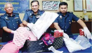  ??  ?? Chik Omar (centre) with the luggage bag used to hide the drugs.