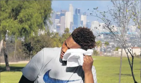  ?? Allen J. Schaben
Los Angeles Times ?? KAY BUTLER towels off at Kenneth Hahn State Recreation Area. In the background is downtown L.A., where the temperatur­e hit 96 degrees. Long Beach, at 105, and Burbank, 104, set daily records, while in Ventura County, Camarillo posted its hottest day...