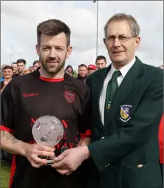  ??  ?? Kevin Murphy receives his man of the match award from Seán Parker of the Wexford League.