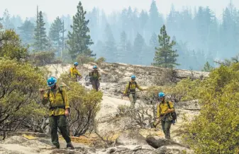  ?? Santiago Mejia / The Chronicle ?? U.S. Forest Service wildland firefighte­rs head toward Wawona Road near Tunnel View after cutting off the long-burning Ferguson Fire’s fuel in Yosemite National Park.