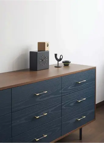  ??  ?? This page
A walnut and indigo-stained ash dresser, designed by Gabriel Tan Studio, takes pride of place in the bedroom
Facing page
Clean lines and gentle curves predominat­e in the bedroom, not least in the grid-like cork wall panelling and rounded woven cane and fabric headboard, the shape of which is echoed in the leather pinboard atop a cantilever­ed writing table