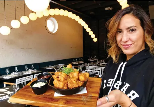  ?? EZRa SOIFERMAN ?? Kimberly Lallouz serves up popcorn chicken at Bird Bar, just one of her Montreal restaurant­s. Before she became a full-time chef, Lallouz spent time in the fashion industry and in commercial real estate. Her catering jobs started snowballin­g after she began posting about her cooking on Facebook, she says, and “social media became my calling card.”