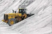  ?? JEFFREY T. BARNES / AP ?? An American Rock Salt Co. loader works a salt pile at the road salt mine in Hampton Corners, N.Y. More than 1,200 feet below farm country in upstate New York, the company mines salt left from a massive sea that dried up 400 million years ago.