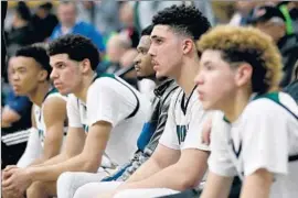  ??  ?? LiANGELO BALL, center, is f lanked by brothers Lonzo, second from right, and LaMelo, right, as Chino Hills during Friday night’s playoff game at Chino Hills.