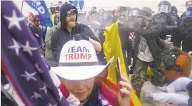  ?? JOHN MINCHILLO/ AP ?? President Donald Trump supporters try to break through a police barrierWed­nesday at the Capitol inWashingt­on as Congress prepared to affirm President- elect Joe Biden’s win.