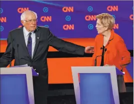  ?? Paul Sancya The Associated Press ?? Sen. Bernie Sanders, I-VT., gestures toward Sen. Elizabeth Warren, D-mass., during Tuesday’s Democratic presidenti­al primary debate in Detroit.