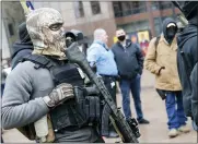  ??  ?? An armed protestor stands outside the Ohio Statehouse Jan. 17, in Columbus, Ohio.