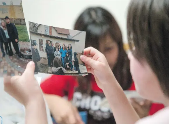  ?? KAYLE NEIS ?? Lora Cardinal, 7, daughter of Tyler Applegate — who was fatally shot in July 2017 — looks at a picture which includes her father. “He was the bestest daddy,” she says.