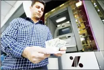  ??  ?? A man withdraws Iranian rials from an automated teller machine in the capital Tehran on July 31. Iran’s currency traded at a fresh record-low of 119,000 to the dollar on Tuesday, a loss of nearly two-thirds of its value
since the start of the year as...