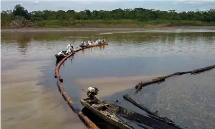  ?? Photograph: Petroperu/AFP/Getty Images ?? Workers attempting to stop the flow of oil in the Cuninico River in September following the spill.