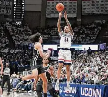  ?? Jessica Hill/Associated Press ?? UConn's Jordan Hawkins shoots over Providence's Devin Carter, left, during the second half on Wednesday in Storrs.