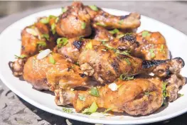  ?? JUNFU HAN/TNS ?? Steven Raichlen uses a method he calls “smoke-roasting” for these crispy Maple-Sriracha Chicken Drumsticks.