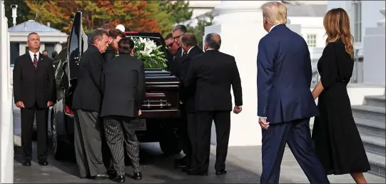  ??  ?? LAID TO REST: Donald Trump and First Lady Melania follow hand-in-hand as the casket of his late brother Robert is placed in a hearse on Friday