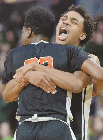 ?? STAFF PHOTO BY CHRISTOPHE­R EVANS ?? WOO-HOO! Brighton’s Mykel Derring, left, and teammate Quincy Taylor celebrate their 82-58 victory over Nashoba in the boys Division 2 state final yesterday in Springfiel­d.