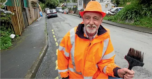  ?? PHOTO: ROSS GIBLIN/STUFF ?? Russell Taylor with the yellow lines he hand-painted on Aro Valley’s Holloway Rd. Wellington City Council looks set to make honest lines out of his illegal markings.