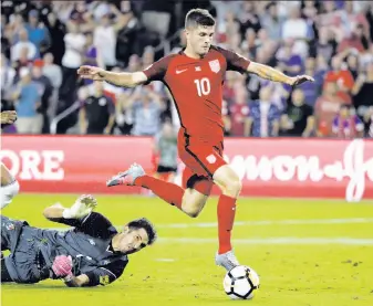  ?? John Raoux / Associated Press ?? Christian Pulisic of the U.S. gets past Panama goalie Jaime Penedo to score eight minutes into the match. “He was able to just disrupt them in so many ways,” said teammate Jozy Altidore.