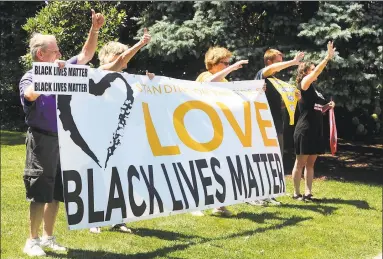  ?? Hearst Connecticu­t Media file photo ?? Participan­ts wave to passing traffic during a Black Lives Matters rally held on the Sherman Green in Fairfield in 2016.