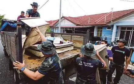  ?? ?? FXXXXX
Policemen and General Operations Force personnel assisting in post-flood clean-up in Taman Seri Bayu, Tumpat, yesterday.