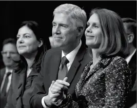  ?? ASSOCIATED PRESS ?? SUPREME COURT JUSTICE NOMINEE NEIL GORSUCH (center) hold the hands of his wife Marie Louise Gorsuch (right) as they listen to opening statements on Capitol Hill in Washington on Monday during his confirmati­on hearing before the Senate Judiciary...