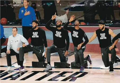  ?? FOTO PROFIMEDIA ?? Basketbali­sté LA Lakers s LeBronem Jamesem (uprostřed) klečí před zápasem NBA na podporu boje proti rasismu