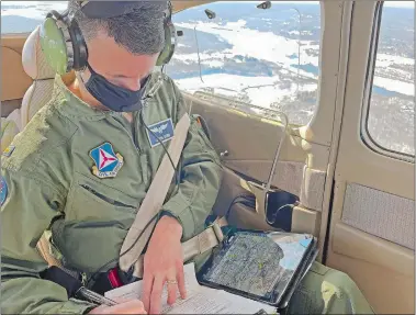  ?? JULIA BERGMAN/THE DAY ?? Civil Air Patrol crew member Jason Otrin marks down a checkpoint while surveying ice conditions over the Connecticu­t and Thames rivers Saturday.