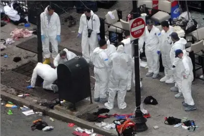  ?? DARREN MCCOLLESTE­R, GETTY IMAGES ?? Investigat­ors work at the crime scene on Boylston Street following Monday’s bomb attack at the Boston Marathon. Security is tight in the city of Boston following the explosions near the finish line that killed three people and wounded hundreds more.