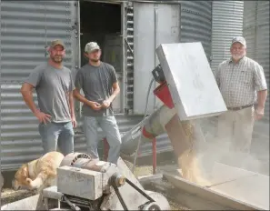  ?? PHOTOS BY CAROL ROLF/CONTRIBUTI­NG PHOTOGRAPH­ER ?? James Schaefers, from left, Kyle Schaefers and Chris Schaefers watch as soybeans are loaded from one of their storage bins into a truck, which would take the beans to Riceland Foods to be processed for Ozark Mountain Poultry.