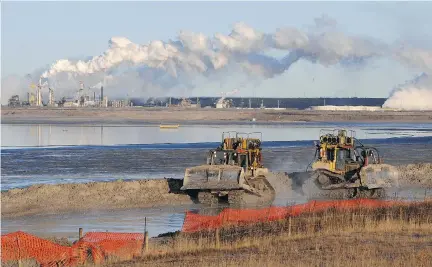  ?? MARK RALSTON/AFP/GETTY IMAGES ?? Workers use heavy machinery in the tailings pond at the Syncrude oilsands extraction facility near Fort McMurray, Alta. A new study suggests that the Alberta oilpatch could make significan­t cuts in methane emissions for very little cost.