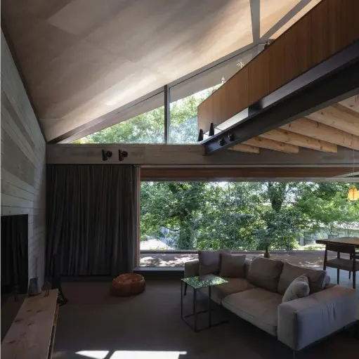  ??  ?? Left
Throughout the home, exposed walls and beams frame oversized openings that accentuate the connection to the outside. The restrained use of finishes and materials means that wood and grey tones continue from structure to furnishing­s, blurring the lines between the two