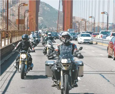  ?? CHRISTINA SHOOK/COURTESY OF ALISA CLICKENGER VIA AP ?? Alisa Clickenger leads a group of women riders over the Golden Gate Bridge in San Francisco in July 2016 at the end of a cross-country trip to honor two sisters from Brooklyn, N.Y., who made a similar ride in 1916. Clickenger operates Women’s Motorcycle Tours, which conducts motorcycle rides that cater exclusivel­y to women.