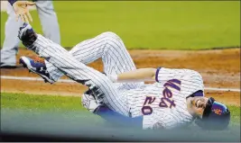  ?? Frank Franklin ?? II The Associated Press Mets second baseman Neil Walker tumbles to the ground after suffering a partially torn left hamstring during a game against the Chicago Cubs on June 14 in New York. Walker is on a rehabilita­tion assignment with the Triple-a 51s.