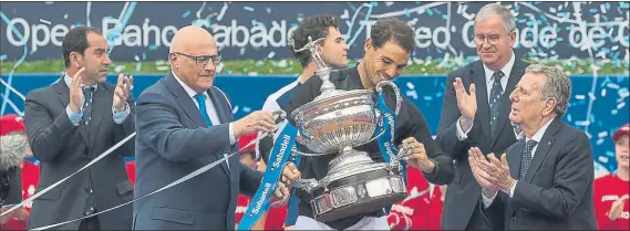  ??  ?? Albert Costa, Albert Agustí y Javier Godó, Conde de Godó, aplauden mientras Nadal sostiene el trofeo de campeón que le entregaron Josep Oliu y Javier Godó tras derrotar a Thiem