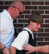  ?? TODD SUMLIN/CHARLOTTE OBSERVER FILE PHOTOGRAPH ?? Charleston shooting suspect Dylann Roof is escorted June 18, 2015, from the Shelby Police Dept. in Shelby, N.C.