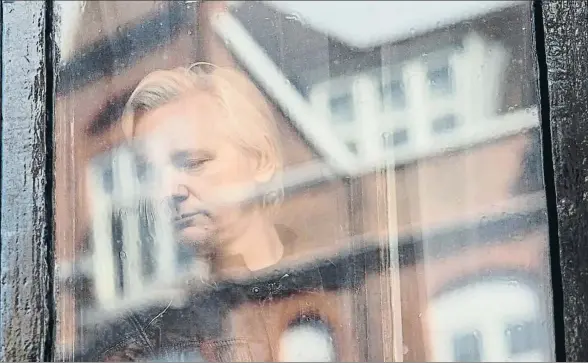  ?? JACK TAYLOR / GETTY ?? Assange detrás de los cristales de la embajada ecuatorian­a en Londres, a punto de salir a un balcón para dirigirse a los medios