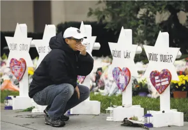  ?? Matt Rourke / Associated Press ?? A person grieves in front of Stars of David bearing the names of those killed at a Pittsburgh synagogue.