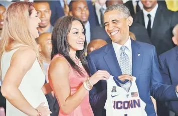  ??  ?? US President Barack Obama (right) shares a laugh with Stefanie Dolson (left) and Bria Hartley while posing with a jersey during an event n honor of the NCAA 2014 Champions, the UConn Huskies Men’s and Women’s Basketball teams in the East Room of the...
