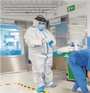  ??  ?? Sanitarios se protegen antes de entrar en un box para atender a un ingresado por coronaviru­s en la UCI del Reina Sofía de Murcia. La imagen no es de primavera: es de este 13 de enero