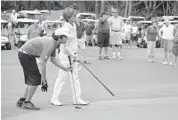  ?? STEVE WATERS/STAFF ?? Nick Staub, 11, of Boynton Beach (left) reads a putt with help from Wycliffe Golf & Country Club’s Lynn Stebbins.