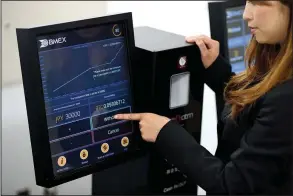  ?? Bloomberg News/ AKIO KON ?? An employee at BITPoint Japan Co. in Tokyo on Thursday demonstrat­es how to use a bitcoin automated teller machine.