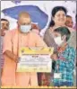  ?? SOURCED ?? Chief minister Yogi Adityanath presenting a certificat­e to a beneficiar­y of “Bal Seva Yojna” in Jaunpur on Monday.