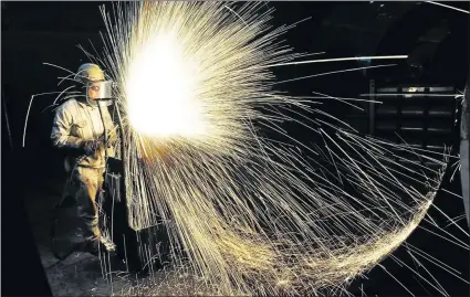  ?? Picture: AFP ?? INDUSTRY SHOCK: A Chinese worker cuts steel in Qingdao in China’s eastern Shandong province