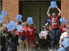  ?? CHARLES KRUPA — THE ASSOCIATED PRESS ?? Massachuse­tts Gov. Charlie Baker, right center, and Lt. Gov. Karyn Polito, third from left, participat­e in the Ice Bucket Challenge with the man who inspired the event, Pete Frates, seated in center, to raise money for ALS research, at the Statehouse in Boston.