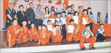  ??  ?? Lee (back row, fourth left) presents the championsh­ip trophy to representa­tives and students of SJKC Chung Hua Miri at the closing ceremony of the fourth Zhong Hua Wushu Inter-School Open Championsh­ip at SMK St Columba.